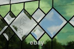 Stained glass window panel, featuring green and clear beveled sections, etched w