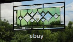 Stained glass window panel, featuring green and clear beveled sections, etched w